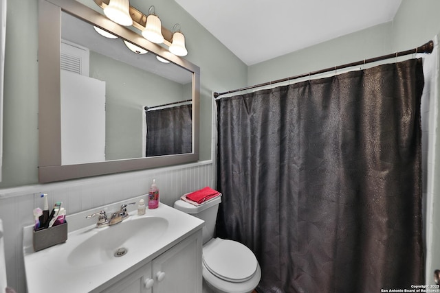 bathroom with toilet, vanity, and curtained shower