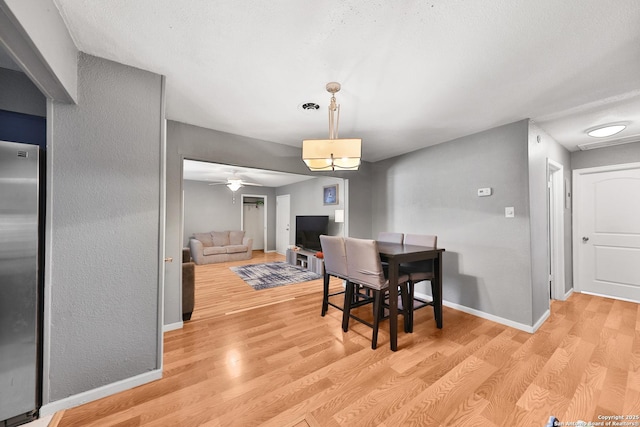 dining room with ceiling fan, a textured ceiling, and light hardwood / wood-style floors