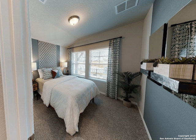 bedroom featuring carpet floors, vaulted ceiling, and a textured ceiling