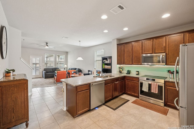 kitchen featuring pendant lighting, stainless steel appliances, sink, kitchen peninsula, and ceiling fan