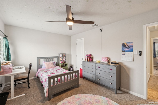 bedroom with ceiling fan, a textured ceiling, and dark colored carpet