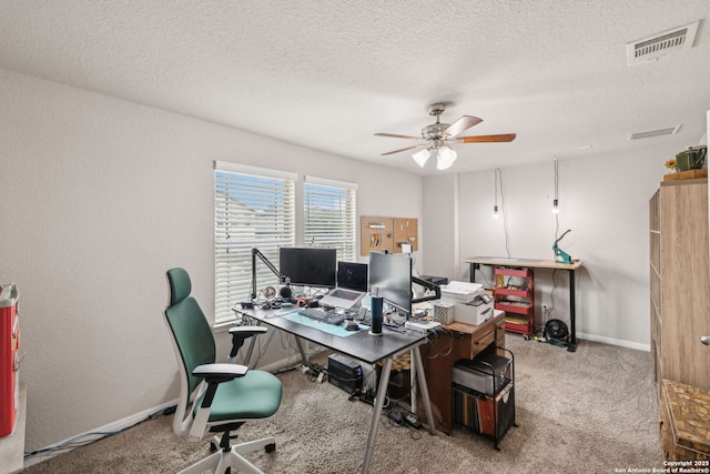 carpeted office space with a textured ceiling and ceiling fan