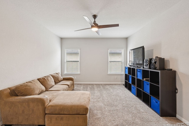 carpeted living room featuring ceiling fan and a textured ceiling