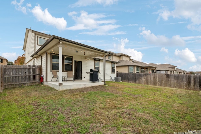 back of property featuring central AC unit, a patio area, and a yard