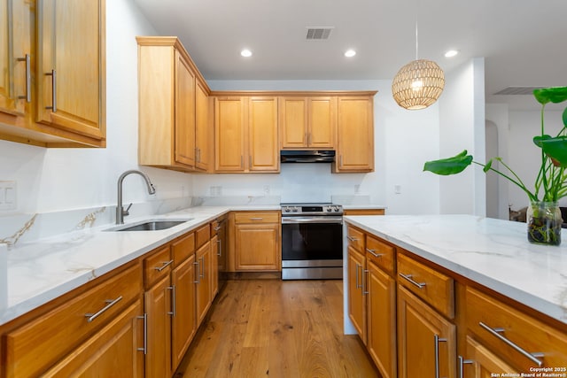 kitchen featuring electric range, sink, light hardwood / wood-style flooring, hanging light fixtures, and light stone countertops