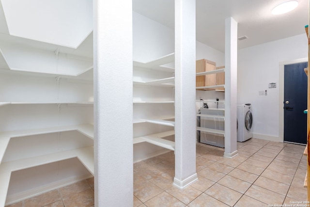 washroom with washer / dryer and light tile patterned flooring