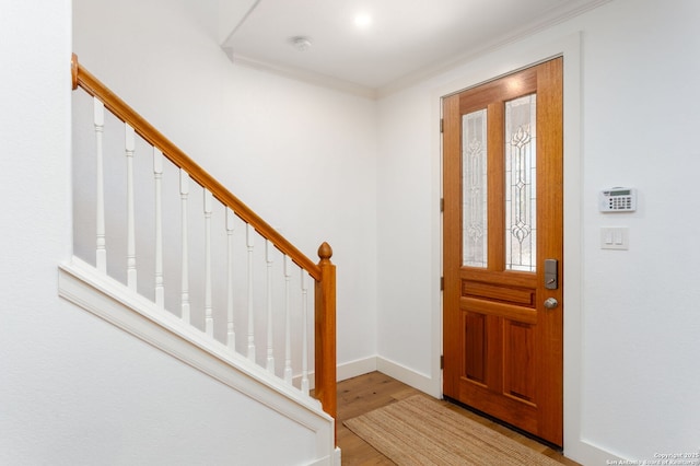 foyer entrance featuring light wood-type flooring and ornamental molding