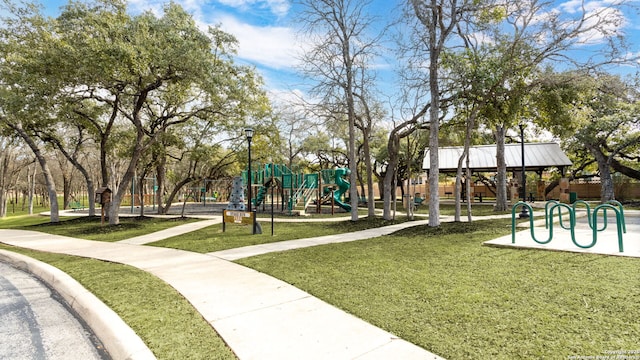 view of home's community with a playground and a lawn