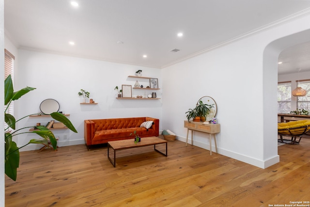 sitting room with crown molding and light wood-type flooring