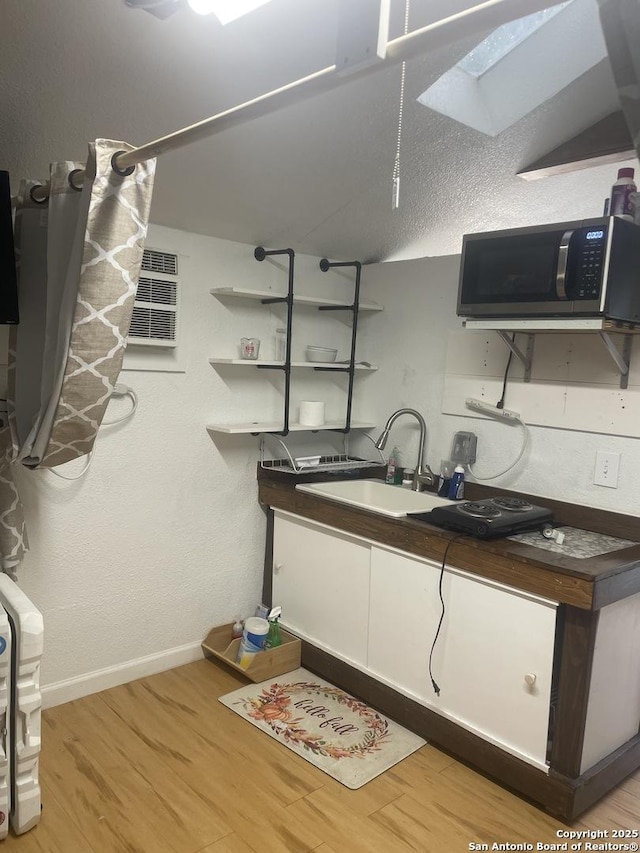 interior space with wood-type flooring, sink, and a wall mounted air conditioner