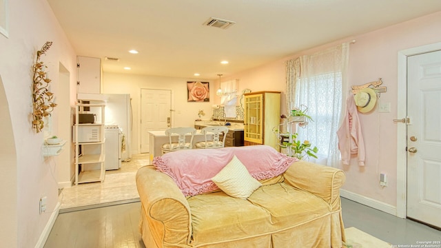 living room with washer / clothes dryer and light wood-type flooring