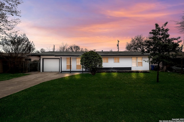 single story home with a garage and a yard