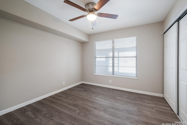 unfurnished bedroom featuring dark wood-type flooring, ceiling fan, and a closet