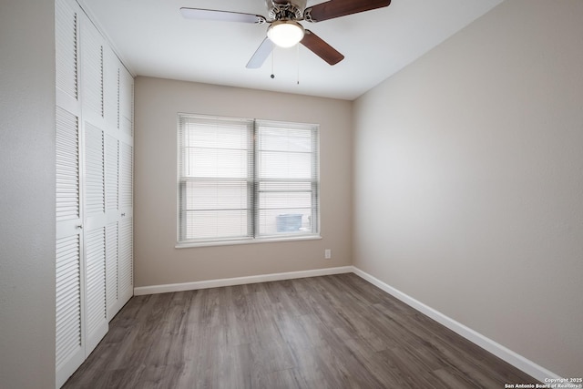 unfurnished bedroom with dark wood-type flooring, ceiling fan, and a closet