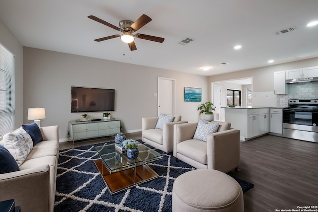 living room featuring ceiling fan and dark hardwood / wood-style floors