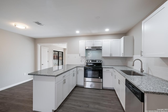 kitchen with light stone countertops, white cabinets, appliances with stainless steel finishes, sink, and dark hardwood / wood-style floors