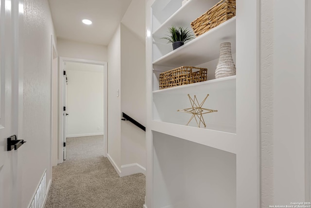 hall featuring light colored carpet