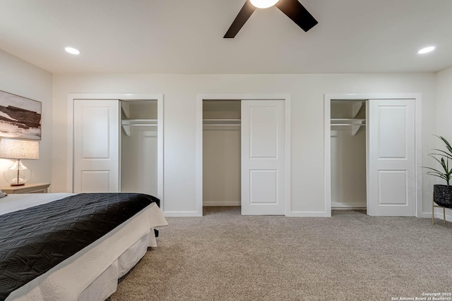 bedroom featuring ceiling fan, multiple closets, and carpet floors