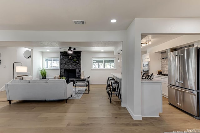 living room with light wood-type flooring and a fireplace