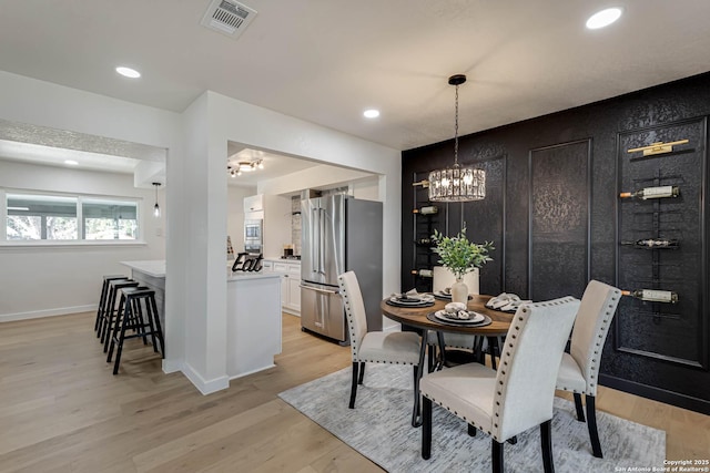 dining room featuring a notable chandelier and light hardwood / wood-style floors