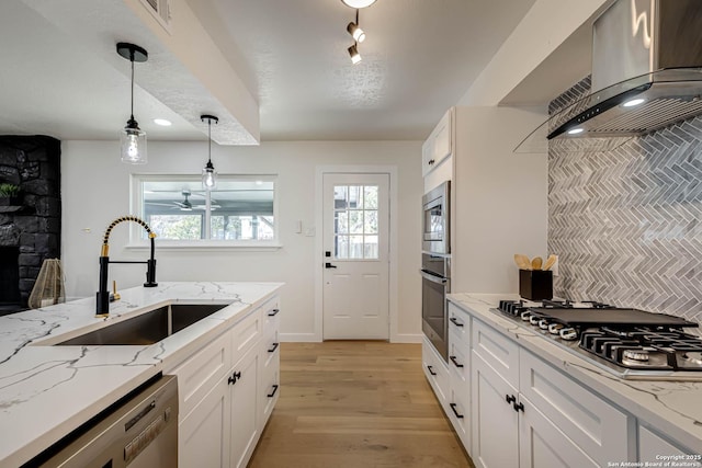 kitchen featuring light hardwood / wood-style floors, pendant lighting, sink, stainless steel appliances, and island range hood