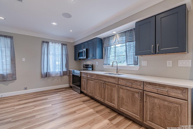 kitchen featuring light wood-type flooring, appliances with stainless steel finishes, sink, and ornamental molding