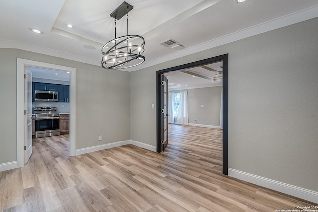 unfurnished dining area featuring light wood-type flooring, ornamental molding, a chandelier, and a tray ceiling