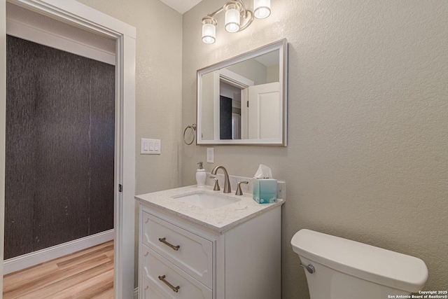 bathroom featuring hardwood / wood-style flooring, toilet, and vanity