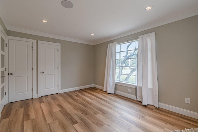 unfurnished bedroom featuring ornamental molding and light hardwood / wood-style flooring