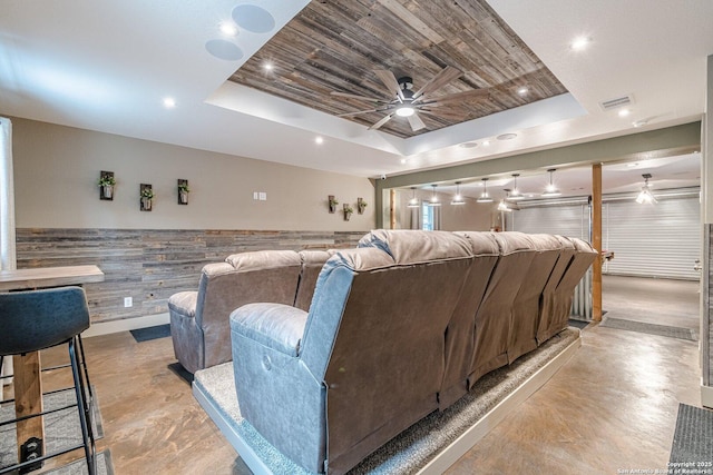 cinema room featuring ceiling fan, wooden ceiling, and a tray ceiling