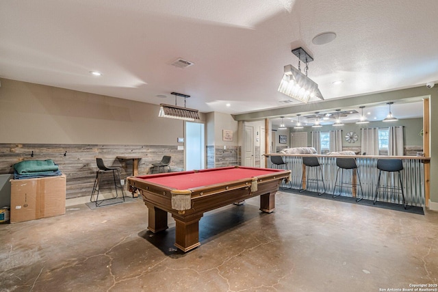 recreation room with wood walls, billiards, concrete floors, and bar