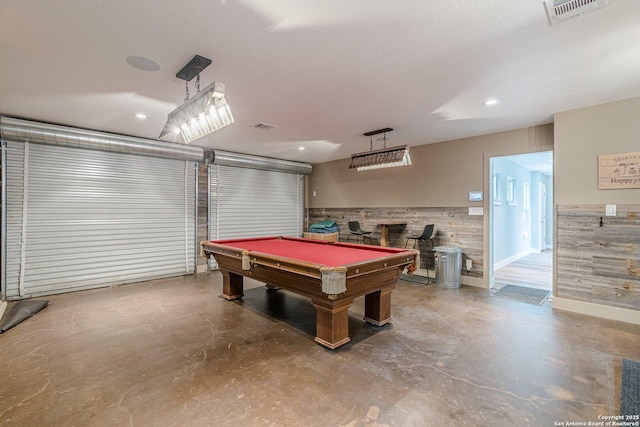 playroom featuring wood walls, pool table, concrete floors, and a textured ceiling