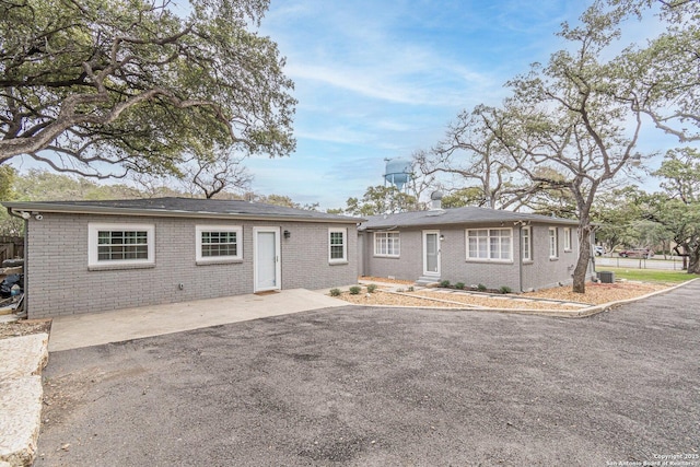 ranch-style home with central air condition unit and a patio