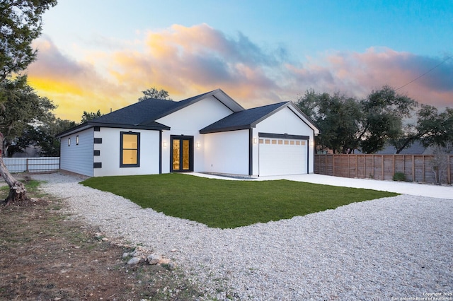 modern farmhouse style home featuring a garage and a lawn