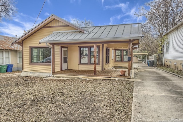 back of house with a standing seam roof, metal roof, and a porch