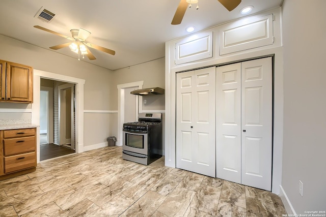 kitchen featuring brown cabinetry, stainless steel range with gas cooktop, visible vents, and light countertops