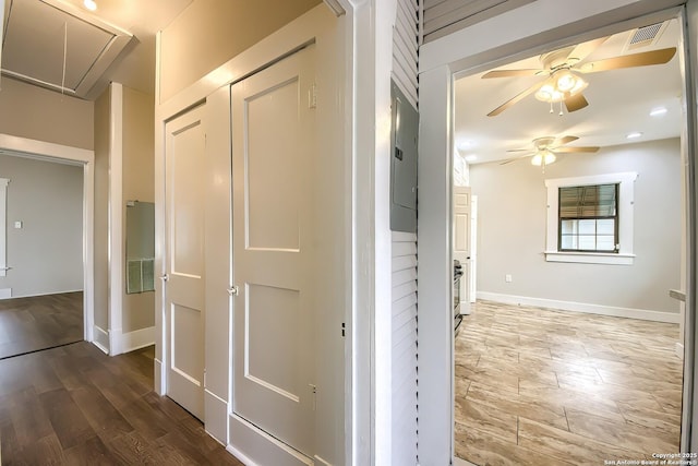 hall featuring attic access, visible vents, baseboards, and wood finished floors