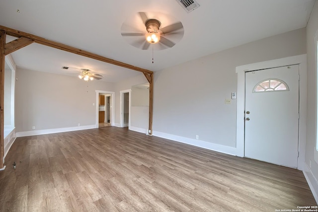 unfurnished living room with baseboards, light wood-style flooring, visible vents, and a ceiling fan