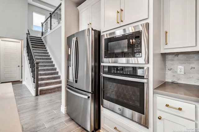 kitchen featuring white cabinetry, appliances with stainless steel finishes, and tasteful backsplash