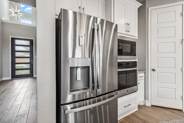 kitchen with a healthy amount of sunlight, stainless steel appliances, and white cabinetry