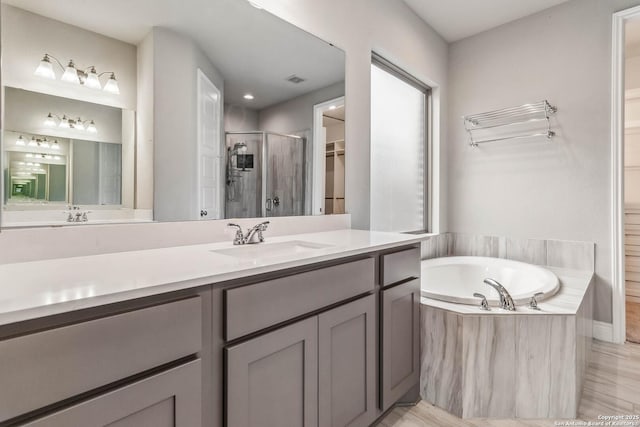 bathroom with independent shower and bath and vanity