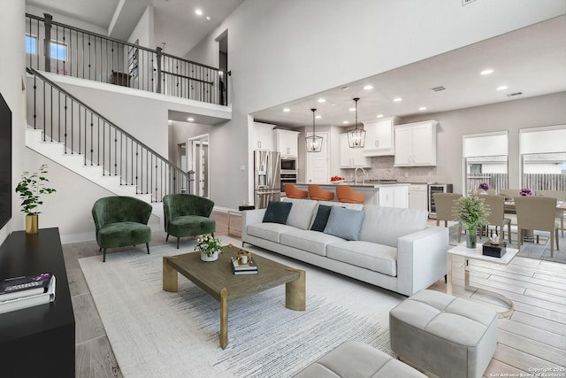 living room with beverage cooler, a towering ceiling, and sink