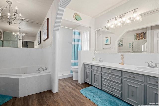 full bathroom with toilet, hardwood / wood-style flooring, separate shower and tub, a chandelier, and vanity