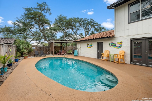 view of swimming pool with a patio area, french doors, and a pergola