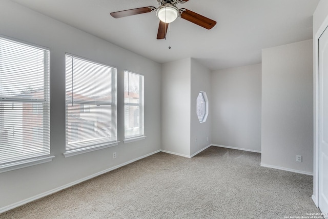 spare room featuring ceiling fan and light colored carpet