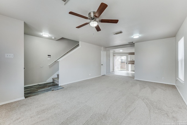 unfurnished living room featuring ceiling fan and carpet flooring