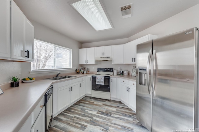 kitchen with sink, white cabinetry, stainless steel appliances, and light wood-type flooring