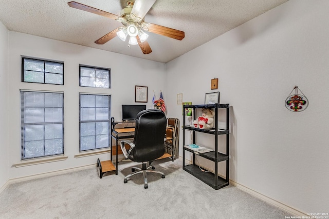 carpeted office featuring ceiling fan, a healthy amount of sunlight, and a textured ceiling