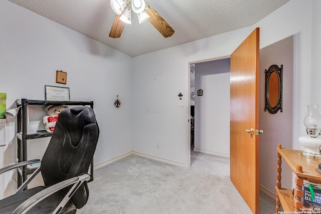 home office featuring light carpet, ceiling fan, and a textured ceiling