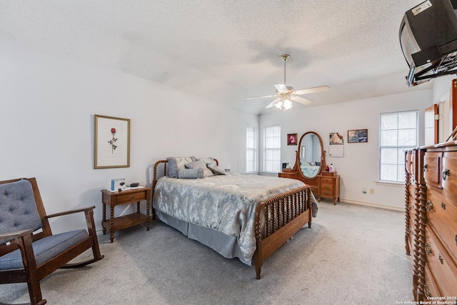 carpeted bedroom with ceiling fan and a textured ceiling